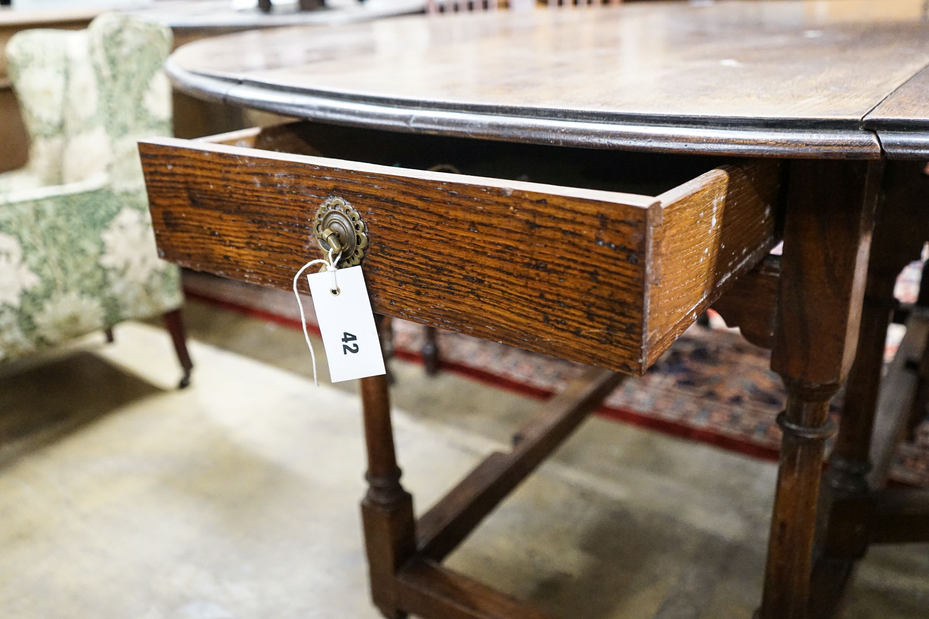 A 17th century style oak gateleg table, with oval top and two frieze drawers, open to 170cm, width 148cm, height 73cm